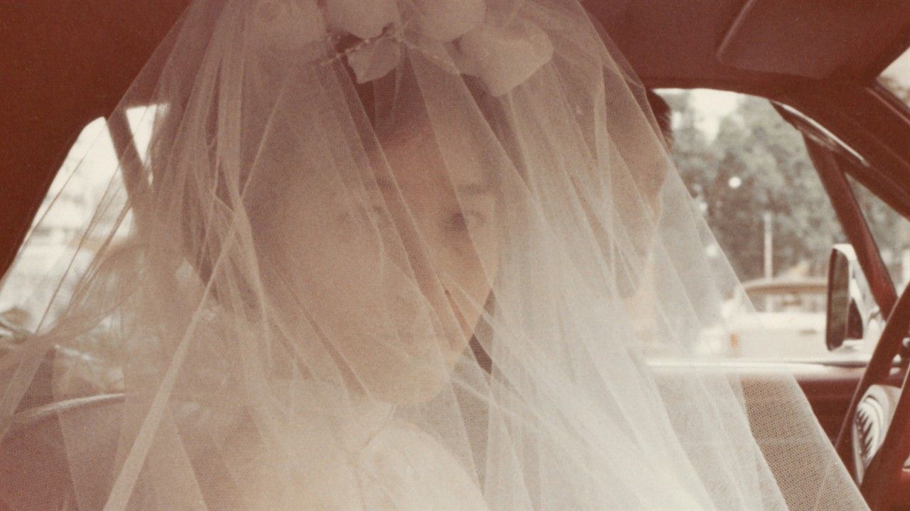 A woman in a wedding veil that covers her face